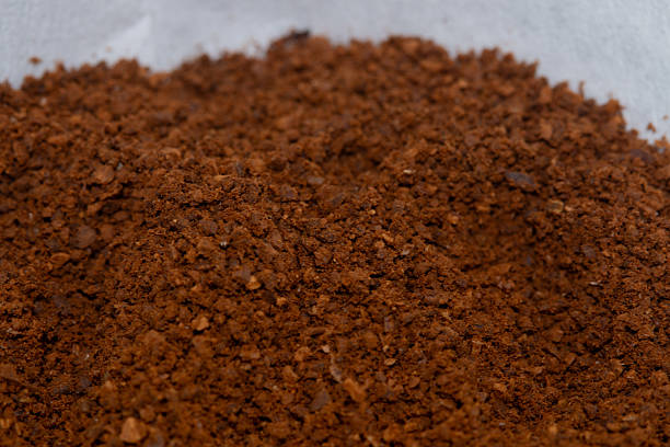 Super macro shot showing fine and coarse coffee grind particles in natural lighting.