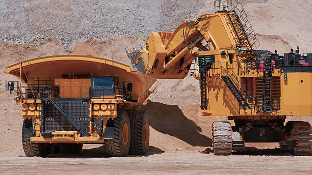 istock Heavy mining machinery extracting minerals in an open pit mine 2246907448