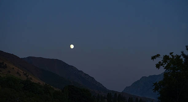 istock In the evening, the moon is visible above the mountain 2246909495