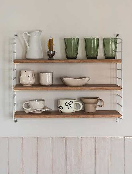 istock Wooden shelf with ceramic dishes on the wall in the kitchen interior 2246911067