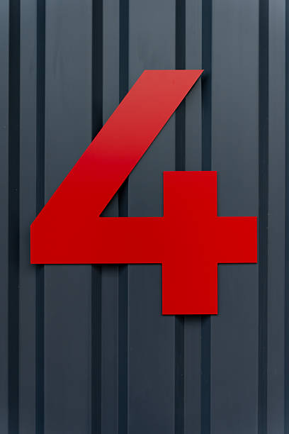 Bright red number 4 sign fixed to vertical metal wall, highlighting directional identification purpose, smooth surface finish and strong contrast used in architectural signage