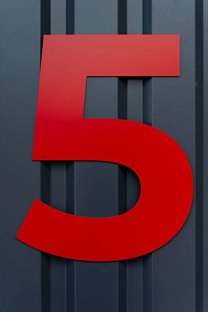 istock Large red number 5 mounted on dark vertical metal cladding, showing bold geometric structure, high contrast and precise positioning used for clear architectural section identification 2246916437
