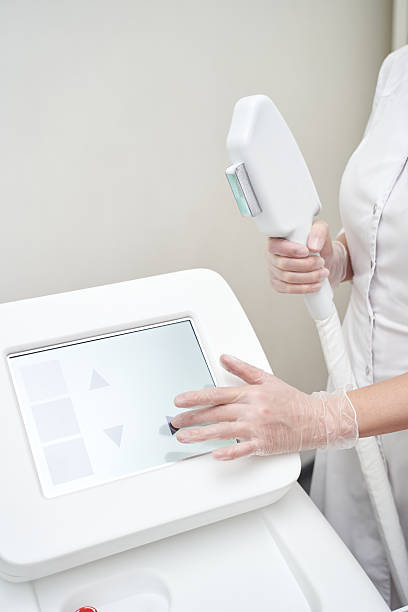 istock Female technician operating laser hair removal machine with touchscreen 2246917482