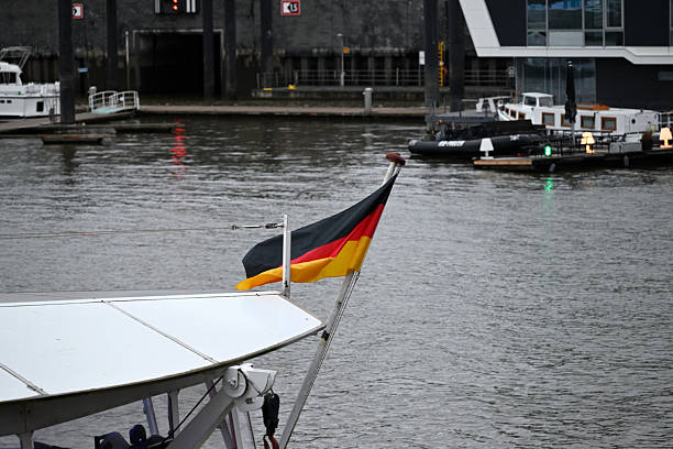 Hamburg, Germany - November 15th 2025 - German flag waves on passenger boat at the Hamburg Harbor. Elbe River, Hafencity, Symbol.
