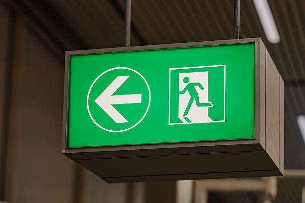 istock A green emergency exit sign with an arrow, shows the direction to safety. 2246920157