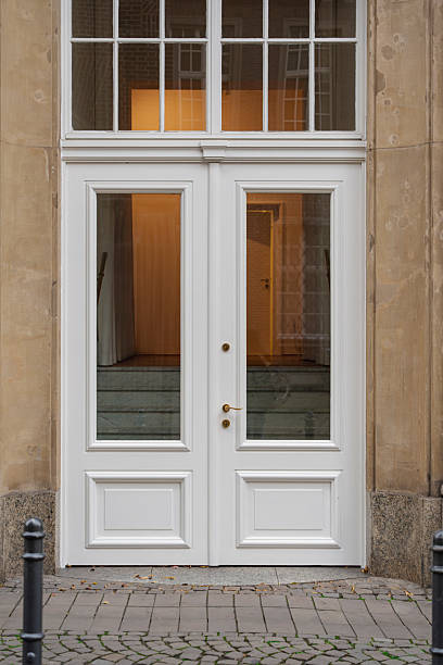 istock Elegant white double doors invite with their clean lines and glass panels. 2246920160