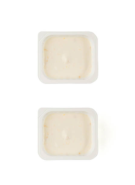 istock Yogurt cup isolated, yoghurt with orange fruits pieces in plastic pot, milk pudding container 2246921076