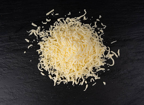 istock Grated mozzarella cheese on black background. Shredded mozarella texture 2246921427