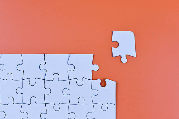 istock White jigsaw puzzle on orange background with one piece missing and nearby, symbolizing final step toward visual and structural completion. 2246921444