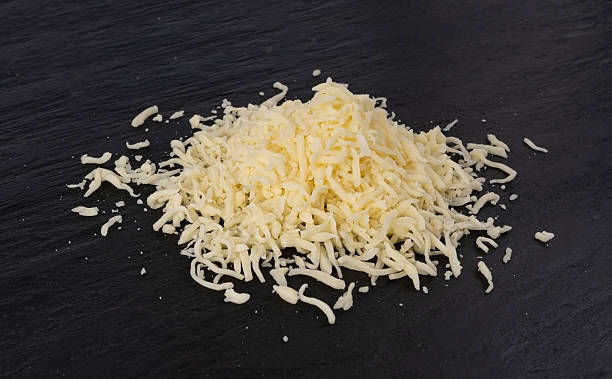 istock Grated mozzarella cheese on black background. Shredded mozarella texture 2246921820
