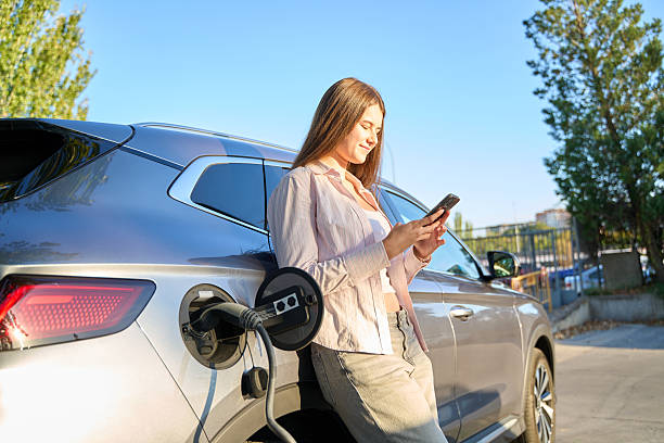 istock Woman using smartphone while charging electric car 2246929179