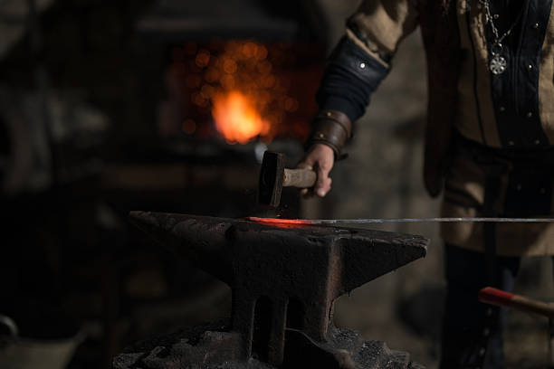 istock A Viking blacksmith with a white beard and braided hair works intently at a forge, hammering glowing metal on an anvil, with flames flickering in the background of a stone workshop. 2246929774