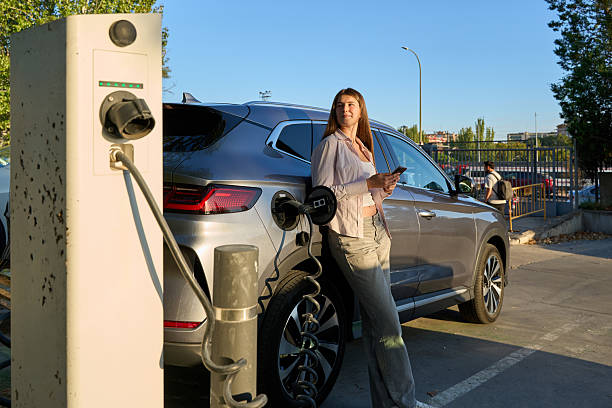 istock Woman charging electric car using smartphone at station 2246930138