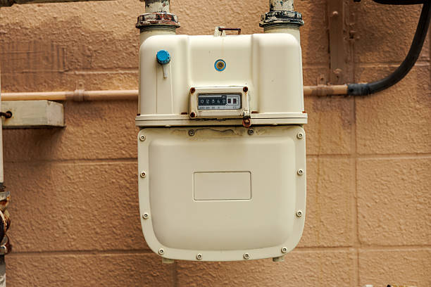 istock Vintage Gas Meter On Exterior Wall With Pipes And Tan Brick Background 2246931494