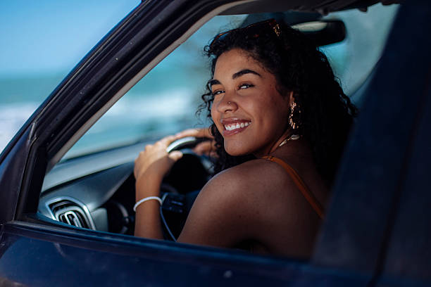 istock Smiling young woman driving on a sunny day 2246932812