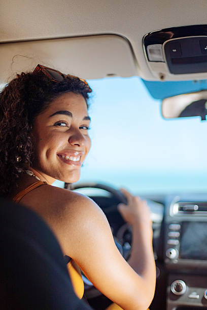 Smiling young woman driving on a sunny day