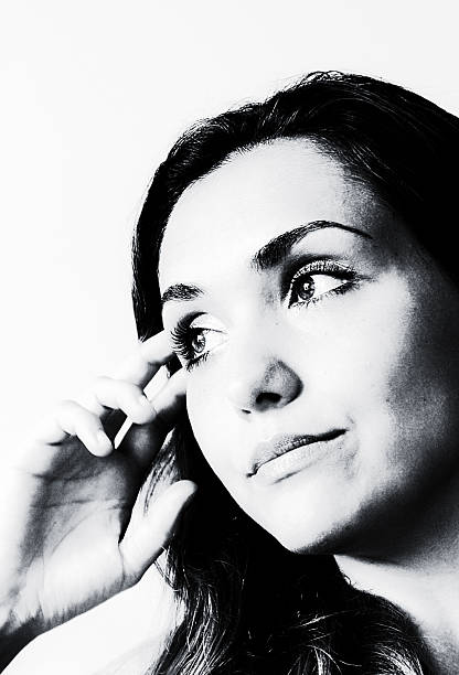 serious woman looking at camera through fingers mask, monochrome