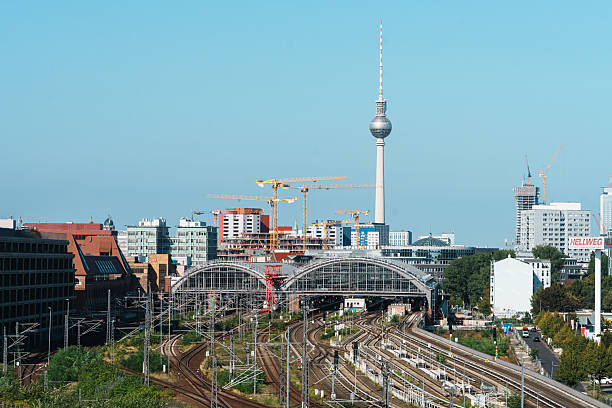 Berlin, Germany, September 27, 2025 - Berlin Cityscape, construction cranes, modern buildings, and the iconic Berlin TV Tower under a cloudy sky
