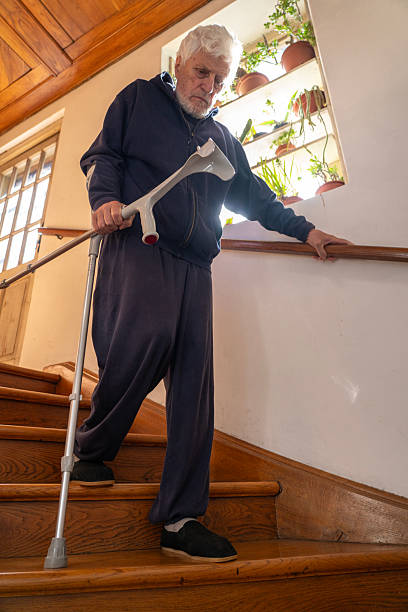 istock Senior man moving down the indoors stairs using crutches 2246941489