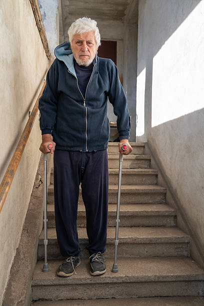 istock Senior man moving down the concrete stairs using crutches 2246941672