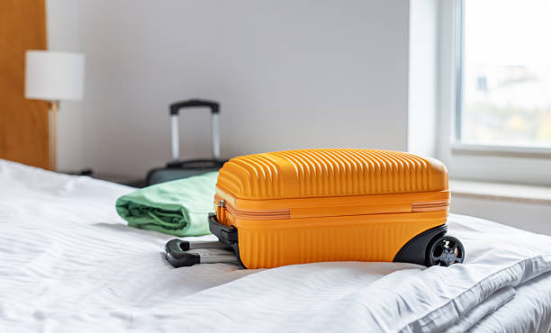 istock Travel suitcase on hotel bed preparing for journey 2246942308