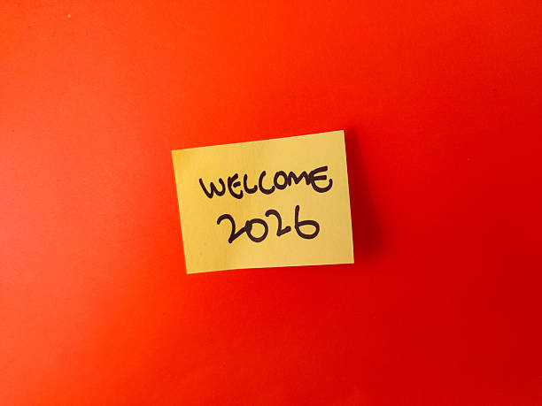istock The image shows a yellow sticky note with the handwritten message WELCOME 2026 on a bright orange background 2246944066
