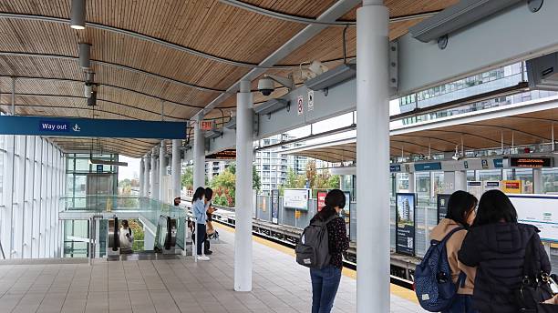 Lansdowne, Richmond, British Columbia, Canada- 3 Oct 2025: skytrain metro train  station have passengers waiting for the metro to arrive in the platform with people coming up from the stairs