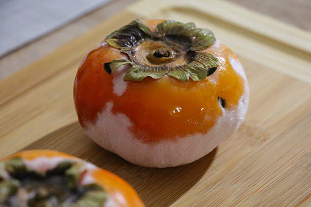 istock Thawing Persimmon on Wooden Board – Macro Texture 2246951042
