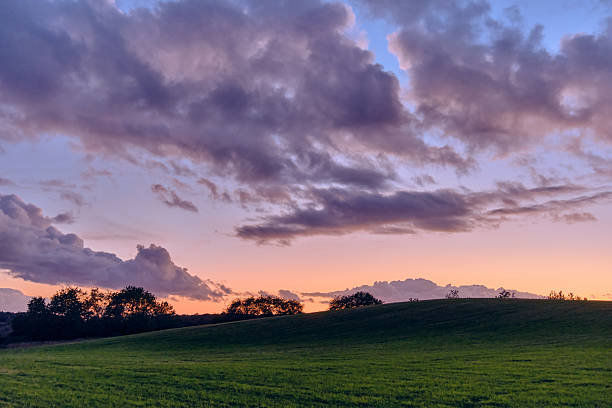 istock Sunset over rolling fields and dramatic clouds in a peaceful rural landscape in Sweden 2246952619