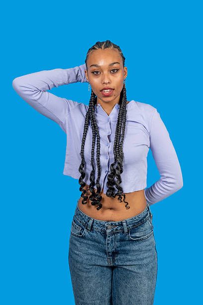 istock Young black woman posing confidently against blue background 2246955398