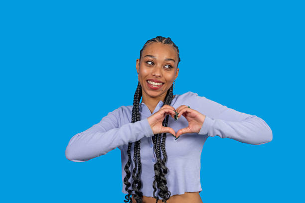 istock Young woman making heart shape with hands smiling at camera 2246955524