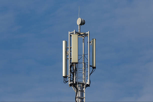 istock A cell phone telecommunications tower with antenna panels and a parabolic antenna against a blue sky 2246956736