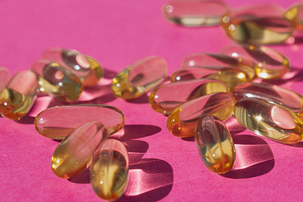 istock Essential fatty acids: yellow Omega-3 softgels isolated on a vibrant pink background 2246957052