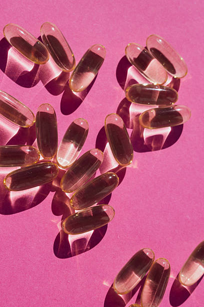 Pop art vitality: bright yellow nutritional capsules scattered across a vivid pink canvas