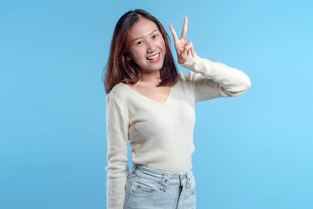 istock Cheerful Indonesian Woman Making Peace Sign 2246959764
