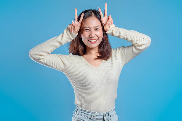 istock Cheerful Indonesian Woman Making Cute Peace Gesture 2246959839
