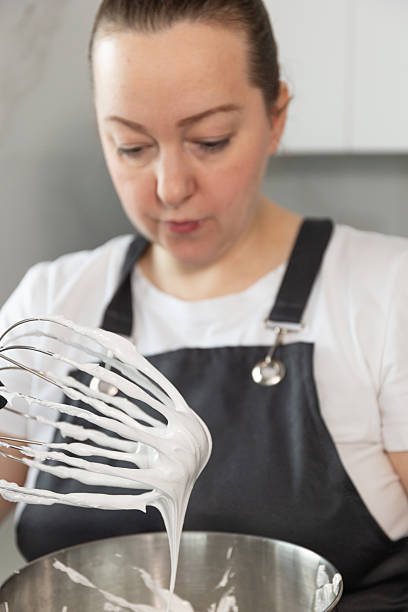 istock Pastry Chef Preparing Meringue With Whipped Cream in a Modern Kitchen Setting 2246960179