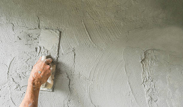 istock Plaster cement wall background, Hand worker holding handle trowel plastering grey mix mortar concrete fresh texture 2246961225