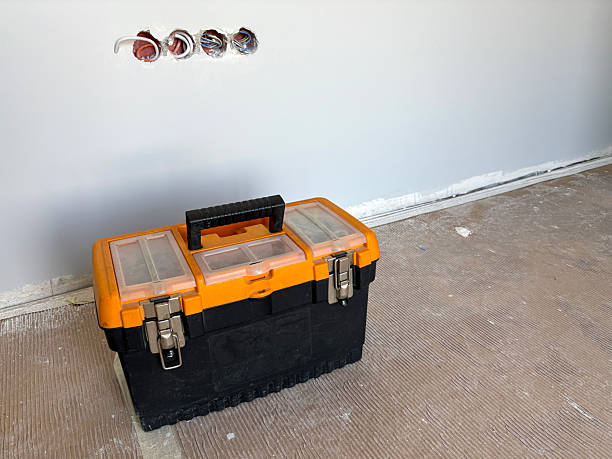 A stack of black tool cases with a bright red toolbox on top. The cases are rugged and designed for storage, showcasing a practical and organized appearance.