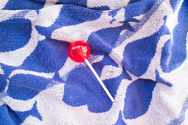 Two orange lollipops on beige background. Minimal concept idea