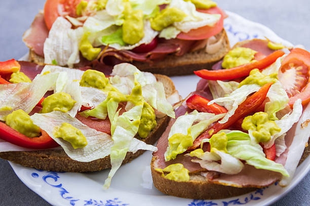 Fresh vegetable lettuce, tomato and paprika on bread with ham and avocado sauce. Home made health dinner