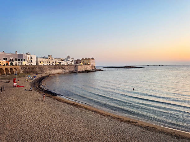 Gallipoli, Italy – July 15, 2024: A scenic view of the beach in a small town of Puglia region, Italy at golden sunset
