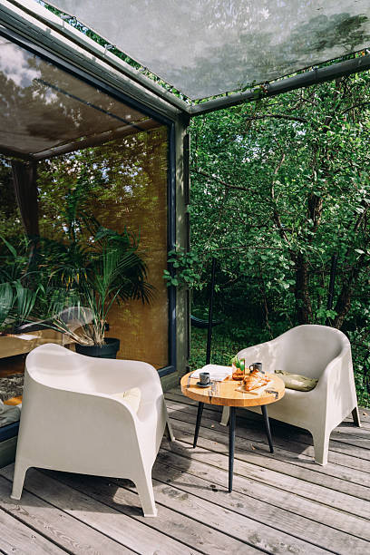 istock Cozy outdoor seating area with modern chairs surrounded by greenery 2246980028