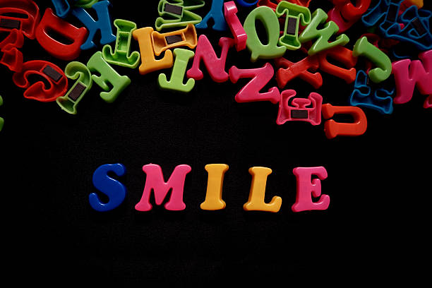 colorful 3d alphabet say smile on black background
