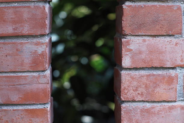 Red Brick Wall with Vertical Opening and Green Foliage View