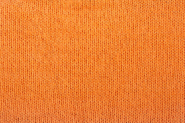 istock Sweater or scarf fabric texture large knitting. Knitted jersey background with a relief pattern. Wool hand- machine, handmade, orange. 2246987007