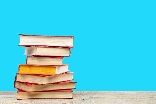 istock Composition with hardback books on wooden deck table and blue background. Books stacking. Back to school. Copy Space. Education background. 2246987106