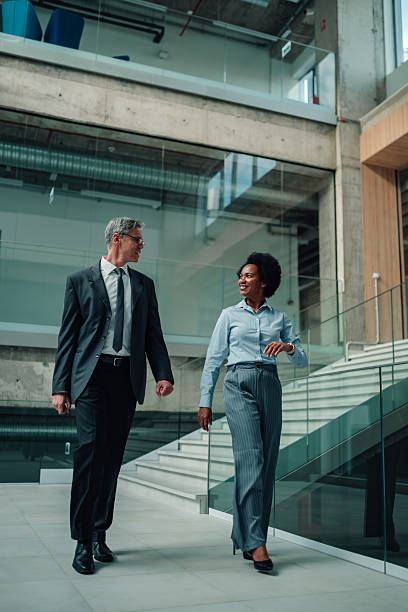 istock Business colleagues walking and conversing in modern office 2246988830
