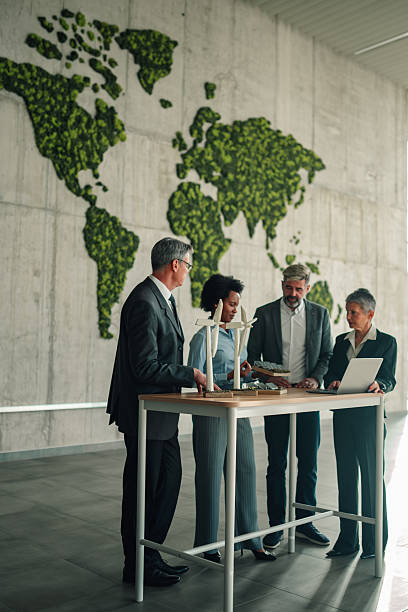 istock Business professionals discussing renewable energy with wind turbine models 2246989205