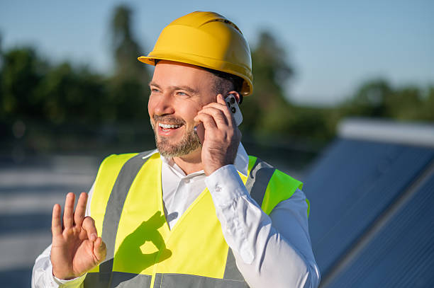 istock Worker with hard hat speaking on mobile near photovoltaic panels 2246990318